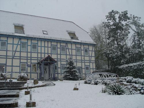 a building with snow on the ground in front of it at Feriendorf Slawitsch in Bad Sulza