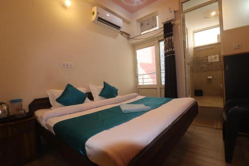 a bedroom with a large bed with blue pillows at Triple One Hotel Tapovan Rishikesh,Near Laxman Jhula in Rishīkesh