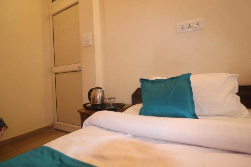 a room with two beds with blue and white pillows at Triple One Hotel Tapovan Rishikesh,Near Laxman Jhula in Rishīkesh