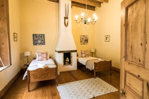 a bedroom with two beds and a fireplace at Garden House in Graaff-Reinet