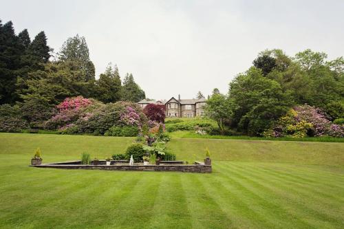 a large grassy yard with a house in the background at Merewood Country House Hotel in Windermere