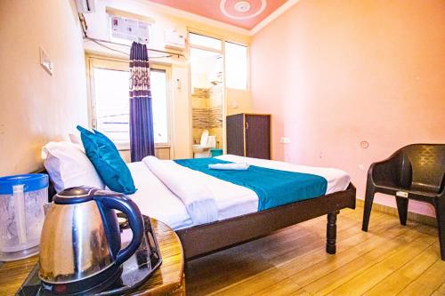 a bedroom with a bed and a table with a tea kettle at Triple One Hotel Tapovan Rishikesh,Near Laxman Jhula in Rishīkesh