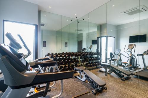 a gym with treadmills and elliptical machines at The Quartier Hotel Phromphong - Thonglor in Bangkok
