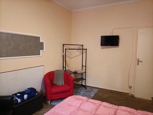 a bedroom with a bed and a red chair at La casa di Laura in Bologna
