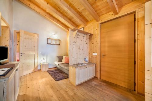 Grushof App Köpfl في سلوديرنو: غرفة معيشة مع أريكة وباب خشبي