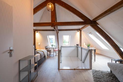 a room with a loft with a bed and a table at B&B aan de Koningsmuur in Dieren