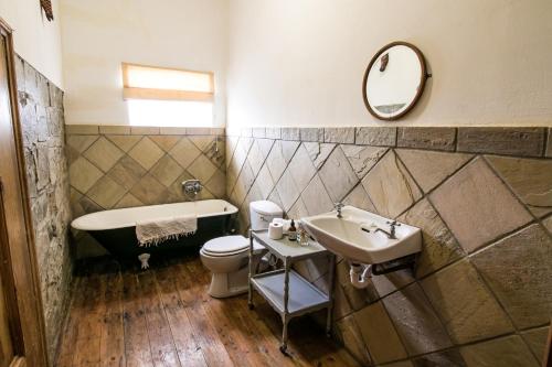 a bathroom with a sink and a tub and a toilet at Garden House in Graaff-Reinet
