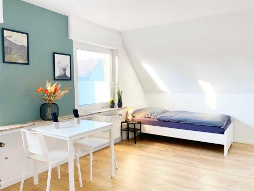 a bedroom with a bed and a table and a table and chairs at Spacious & Chic Apartment with Balcony in Ibbenbüren