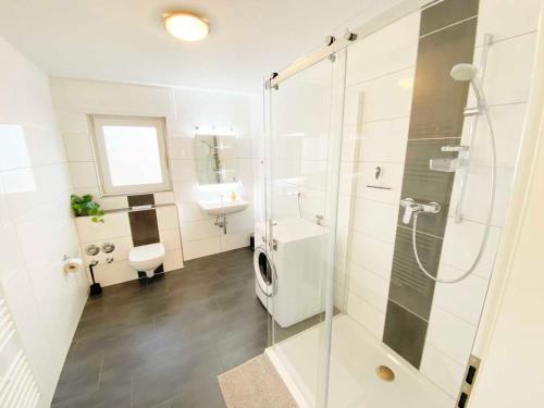 a bathroom with a shower and a toilet and a sink at Spacious & Chic Apartment with Balcony in Ibbenbüren