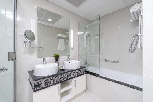 La salle de bains est pourvue de 2 lavabos et d'une douche. dans l'établissement Deluxe 21st Flr Huge 3BR Pool & Gym Near Mall, à Dubaï