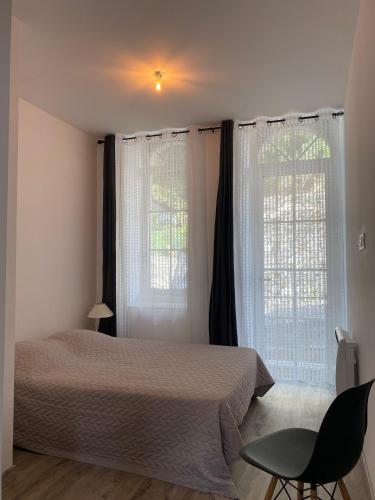 une chambre avec un lit et deux grandes fenêtres dans l'établissement Villa Nostra, à Luz-Saint-Sauveur