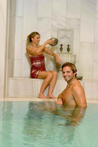 a man and a woman in a swimming pool at Appartement-Haus Blumenhof in Bad Griesbach