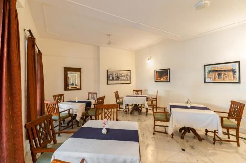 a dining room with tables and chairs with white tablecloths at WelcomHeritage Kalyan Bhawan Hotel in Jaisalmer