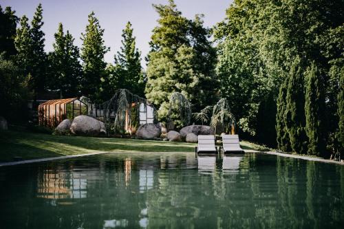 a pool of water with two white benches in it at Vinha Boutique Hotel - The Leading Hotels of the World in Vila Nova de Gaia