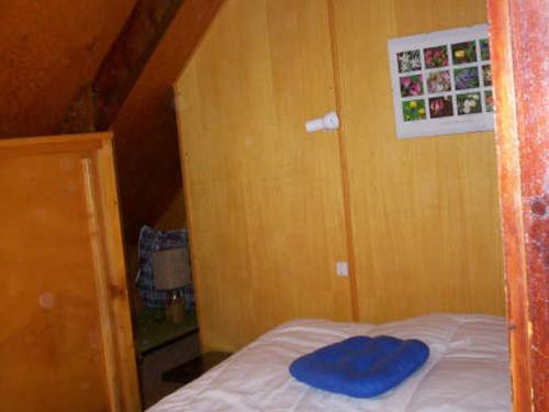 - une petite chambre avec un oreiller bleu sur un lit dans l'établissement Chalet Authentique Proche Pistes et Randonnées - FR-1-515-55, à Corrençon-en-Vercors
