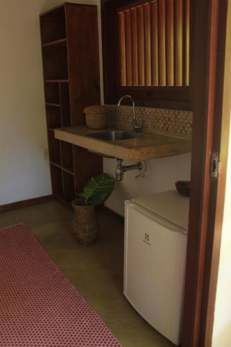 una pequeña cocina con fregadero y encimera en Pousada Aroeira, en Caraíva