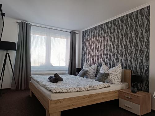 a bed with a teddy bear on it in a bedroom at Penzion Kolonka in Rumburk