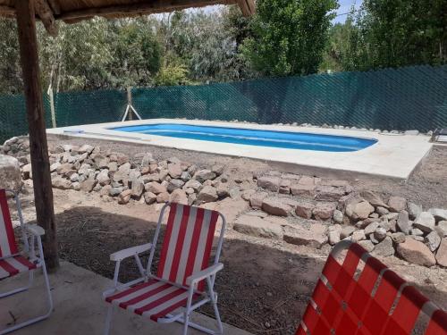 un par de sillas y una piscina en Posta Malbec en Las Compuertas
