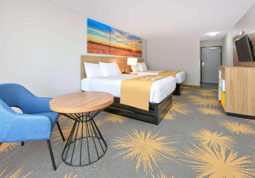 a hotel room with a bed and a table and a chair at Days Inn by Wyndham Tunica Resorts in Tunica Resorts