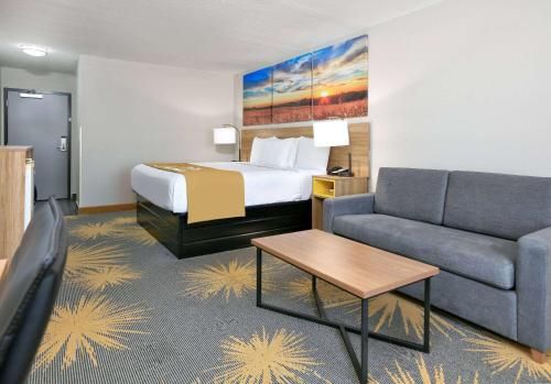 a hotel room with a bed and a couch at Days Inn by Wyndham Tunica Resorts in Tunica Resorts