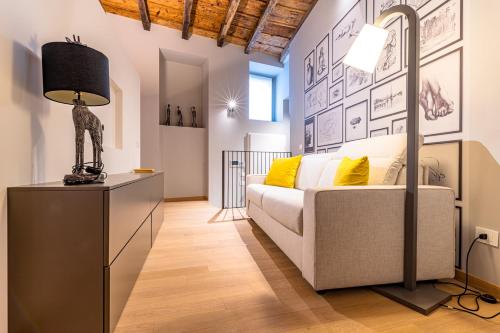 een woonkamer met een bank en een lamp bij BnButler - Bergamo Città Alta - Appartamento di Charme in Bergamo