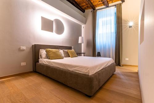 een slaapkamer met een bed en een groot raam bij BnButler - Bergamo Città Alta - Appartamento di Charme in Bergamo