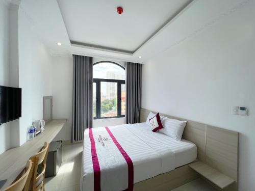 een hotelkamer met een bed en een raam bij Rubillion Hotel - 5-Min Walking to Back Beach in Vung Tau