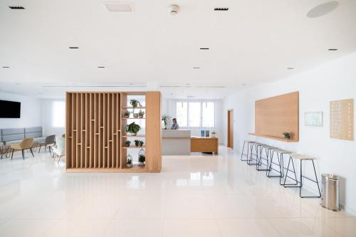 a large white room with a kitchen and a table at Petit Sagitario Adults only in Ciutadella