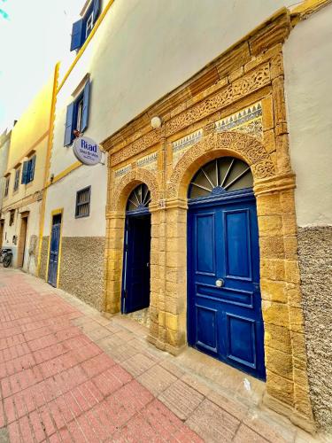 a building with a blue door on a street at Riad chez brahim in Essaouira