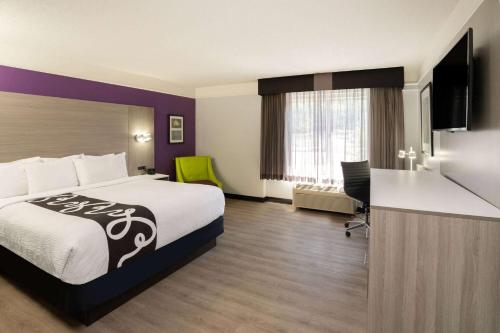um quarto de hotel com uma cama grande e uma secretária em La Quinta by Wyndham Birmingham Hoover em Hoover