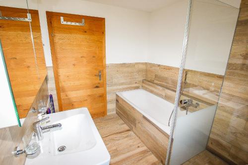 a bathroom with a shower and a sink and a tub at Ferienwohnung Bärtschi in Lenk