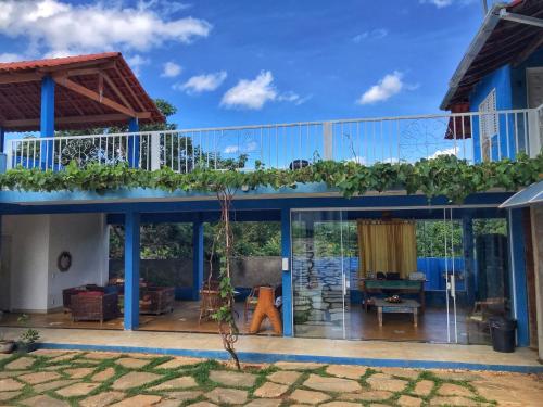 uma casa com uma grande varanda com plantas em Pousada Trilha do Sol em Pirenópolis