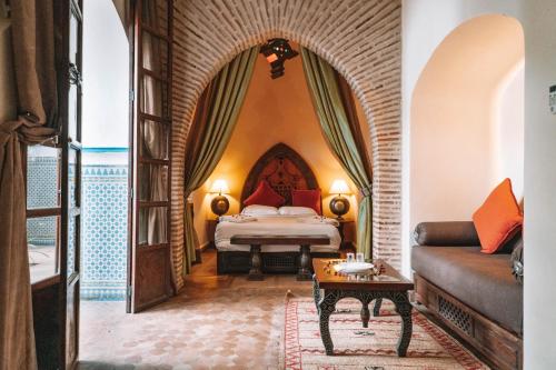um quarto de hotel com uma cama e um sofá em Equity Point Marrakech em Marrakech