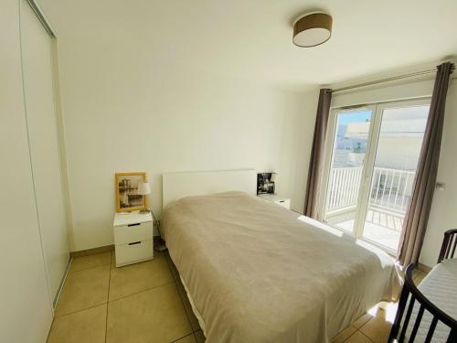 une chambre avec un grand lit et une grande fenêtre dans l'établissement VAL1- One bedroom Cannes Center, à Cannes
