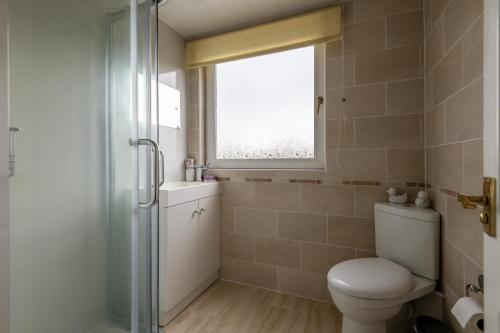 La salle de bains est pourvue de toilettes et d'une fenêtre. dans l'établissement Letham Place - 3 Bedroom House - Sleeps 5 - Log Burner, à Fife