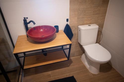 a bathroom with a red sink and a toilet at Chalúpka Rozprávkovo in Šumiac