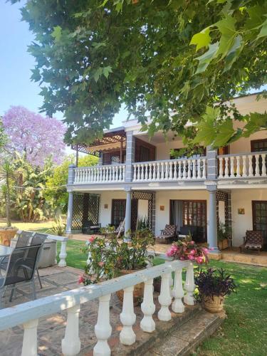 a white fence in front of a house at Golden Candle Guest House in Roodepoort