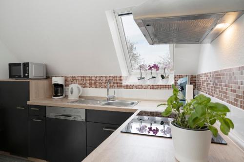 una pequeña cocina con fregadero y ventana en Strandhaus Bornhausen Steuerrad, en Dahme