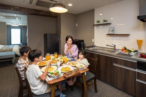 una famiglia seduta a un tavolo che mangia cibo di ＥＮＴ ＴＥＲＲＡＣＥ ＡＳＡＫＵＳＡ - Vacation STAY 85544v a Tokyo