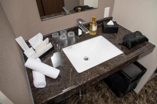 un bancone del bagno con lavandino bianco in una camera d'albergo di ＥＮＴ ＴＥＲＲＡＣＥ ＡＳＡＫＵＳＡ - Vacation STAY 85544v a Tokyo