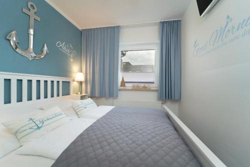 Un dormitorio con una cama con paredes azules y una ventana en Badeweg 4 Haus Bullerbü, App 6, en Scharbeutz