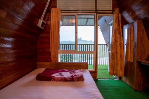 Ambalavayal的住宿－Misty Morning Resorts Wayanad，窗户客房内的小床