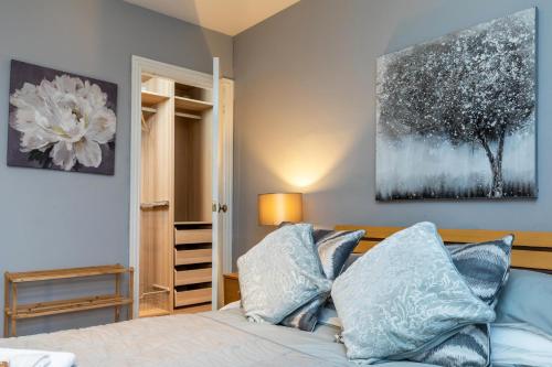 a bedroom with a bed with blue pillows at Modern Aberdeen City apartment free parking in Aberdeen