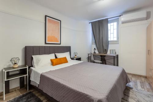 a bedroom with a large bed with an orange pillow at Central apartment in the heart of Historic Center in Athens