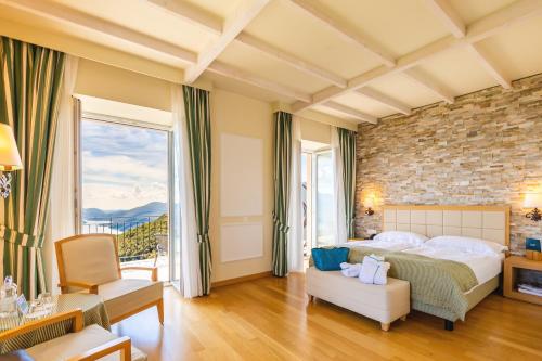 una camera da letto con un letto grande e un muro di mattoni di Kurhaus Cademario Hotel & SPA - Adults Only a Cademario