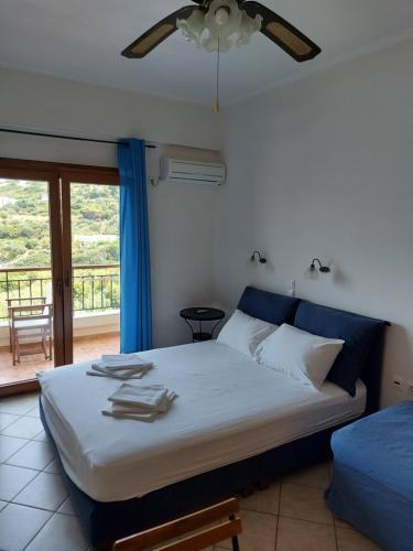 a bedroom with a bed and a window with a view at Anarrousa Studios & Apartments in Evdilos