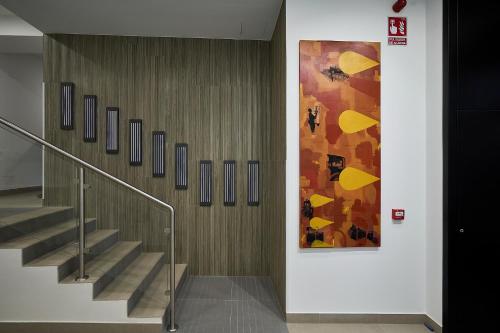 un escalier dans un bâtiment avec une peinture murale dans l'établissement Inés Luna Suites, à Salamanque