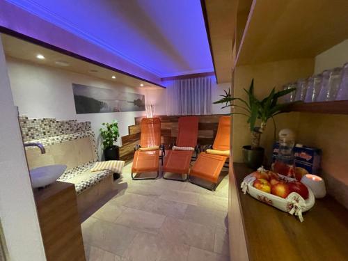 una habitación con una mesa y algunas sillas naranjas en Apart Garni Wiesenhof, en Kappl