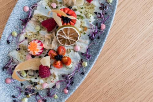 a plate of food with fruit on a table at Petit Sagitario Adults only in Ciutadella