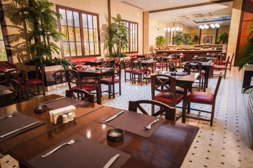 an empty restaurant with wooden tables and chairs at Casa D'or Hotel in Beirut